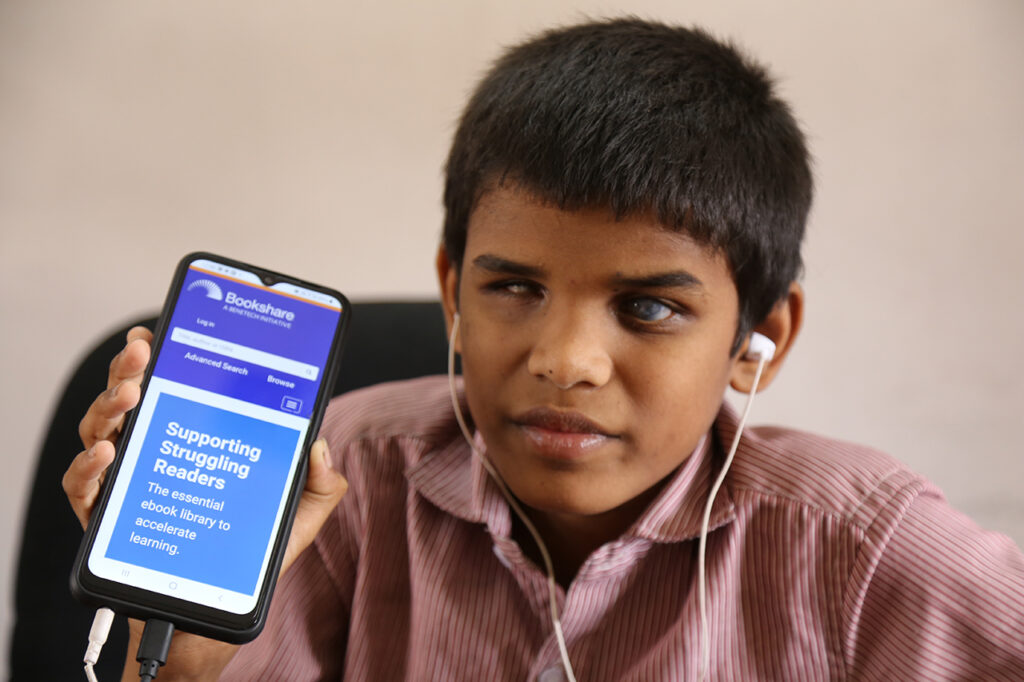 Blind Indian student using Bookshare on phone